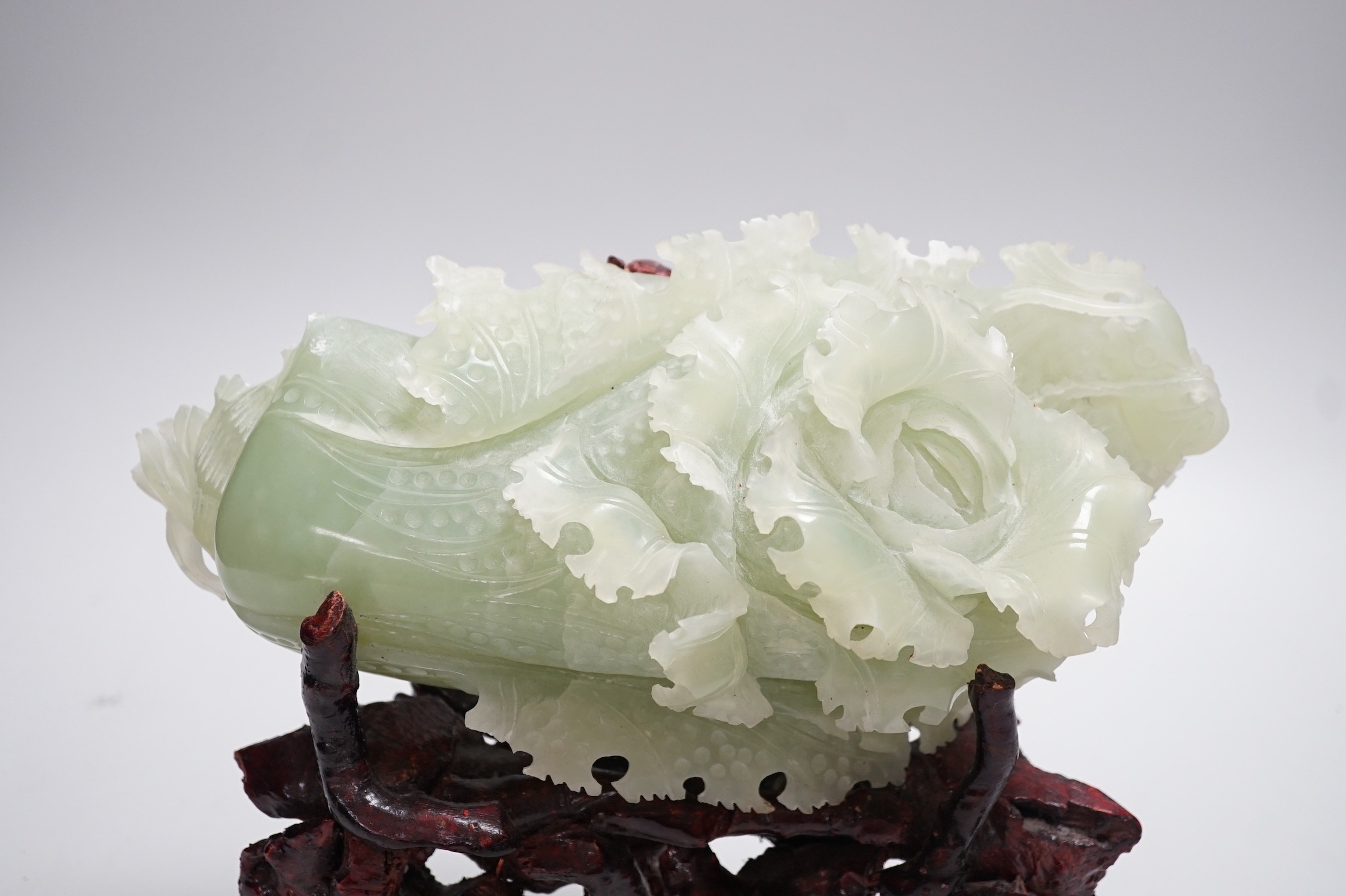 A Chinese bowenite jade carving of a cabbage and a rootwood stand, overall height 24cm